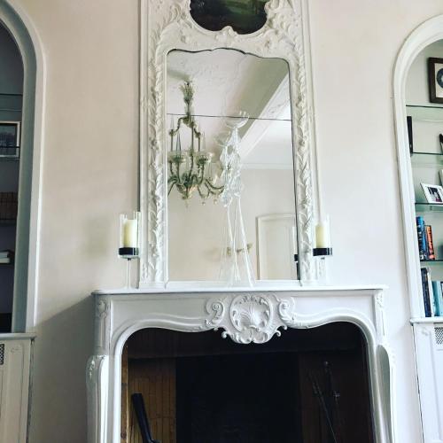 a mirror above a fireplace in a living room at Hôtel Particulier Le 28 - Spa & Art Luxury Design by Alain Ducasse in Aix-en-Provence