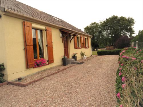 a house with flowers on the side of it at Chambre d'hôtes La Clé du Bonheur in Manthelon