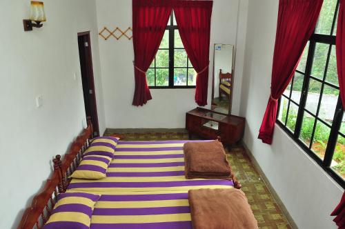 two beds in a room with two windows at Akiko Rest in Nuwara Eliya