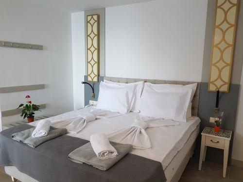 een groot bed met twee handdoeken erop bij Villa White Lagoon in Topola