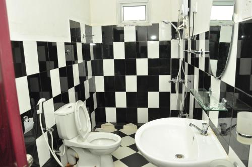 a black and white bathroom with a toilet and a sink at Akiko Rest in Nuwara Eliya