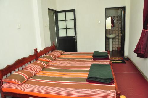 a row of beds lined up in a room at Akiko Rest in Nuwara Eliya