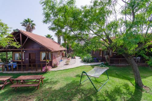 una casa con tavolo da picnic e una sedia in cortile di Tal Nof Cabins a Manot