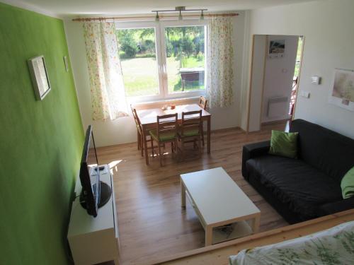 Apartmán Stožec Ema في ستوشيتس: غرفة معيشة مع أريكة وطاولة