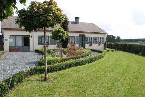 a house with a tree in the front yard at B&B Au fil des saisons sur la Wiels in Fauvillers