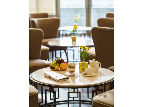 a table with fruit on it in a room with chairs at Solymar Hotel & Beach in Manama