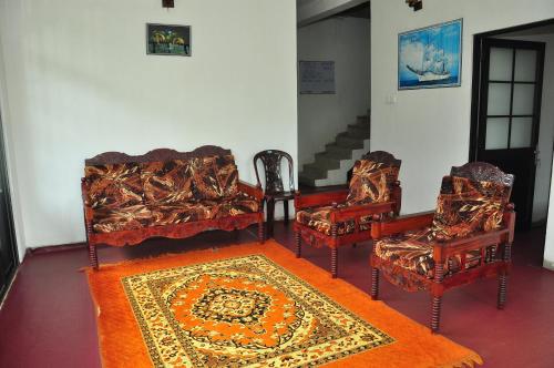 a group of chairs and a rug in a room at Akiko Rest in Nuwara Eliya