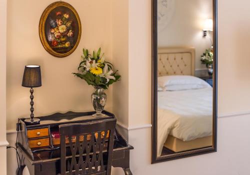 a mirror sitting on a dresser next to a bed at Hotel Patavium in Padova