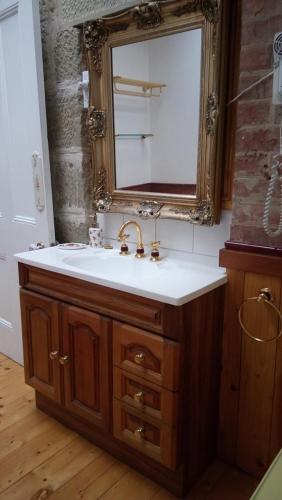 uma casa de banho com um lavatório e um espelho em Natone em Hobart
