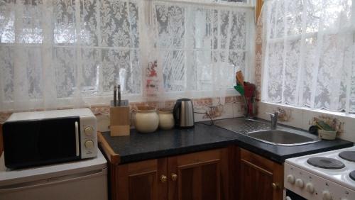 a kitchen with a sink and a microwave at Natone in Hobart