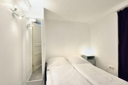 a white room with a bed and a mirror at FeWo Parkblick HH Schanze in Hamburg