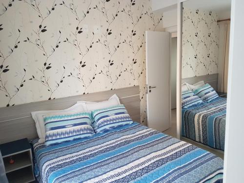 a bedroom with two beds with blue and white sheets at Boulevard Family Club in Bertioga