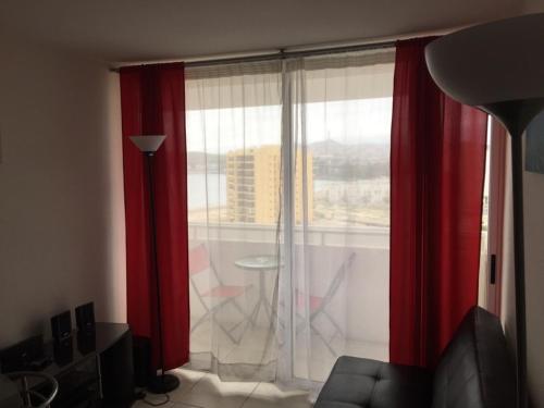 a living room with a window with red curtains at Pronejoet Departamentos La Herradura in Coquimbo