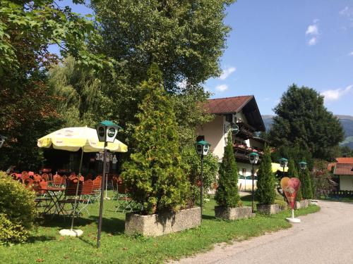 a house with a table and an umbrella and chairs at Appartement Schusternagele in Amlach