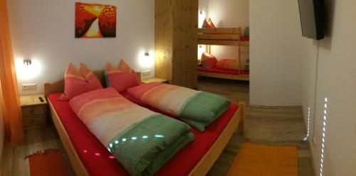 AmlachにあるAppartement Schusternageleのベッドルーム1室(カラフルな枕付きのベッド1台付)