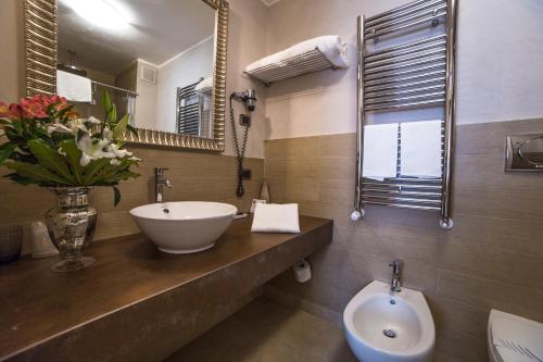 a bathroom with a sink and a toilet and a mirror at Hotel Patavium in Padova