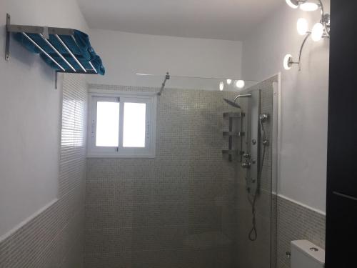 a bathroom with a shower and a window at Roca Mar Tenerife in La Mareta