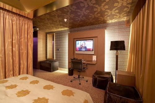 a hotel room with a bed and a television at Hotel Heer Hugo in Heerhugowaard