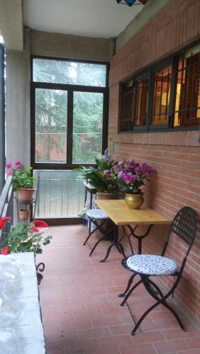 a patio with a table and chairs and flowers at Casa Della Nonna in Radicofani