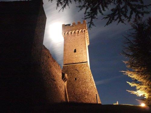 a tall brick tower with the moon in the background at Casa Della Nonna in Radicofani