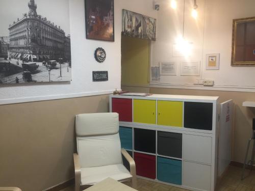 a waiting room with a colorful dresser and a chair at Hostal Murcia in Madrid