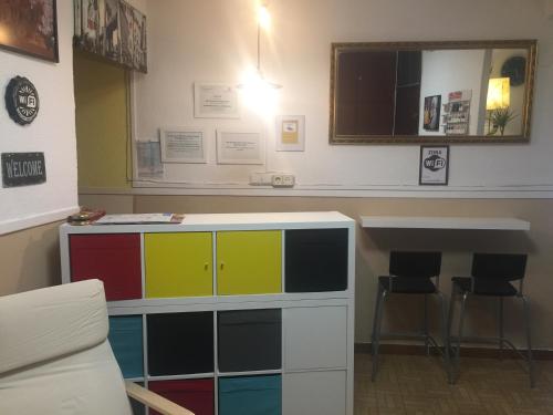 a room with a colorful cabinet with two chairs at Hostal Murcia in Madrid