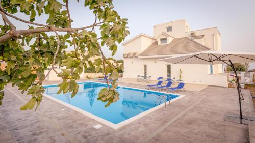 a villa with a swimming pool and an umbrella at Villa Patrizia Selinunte in Marinella di Selinunte