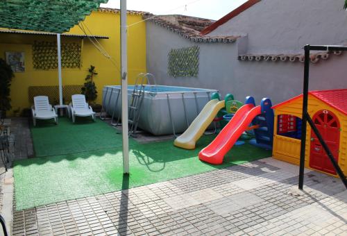 Imperial Mérida في ماردة: حديقة خلفية مع ملعب مع زحليقة ومسبح