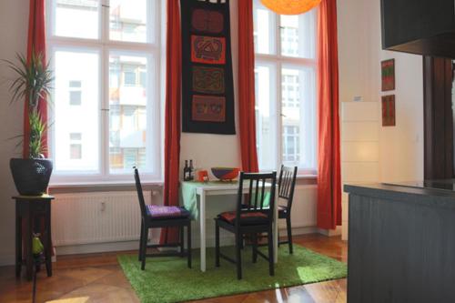 een keuken met een tafel, stoelen en ramen bij Berlin Apartments Mitte in Berlijn