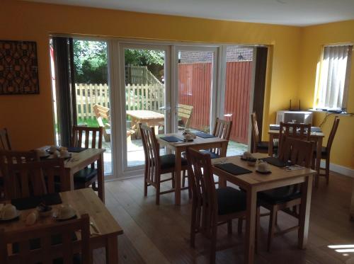 a dining room with tables and chairs and sliding glass doors at B&B Dorwyn Manor in Avebury