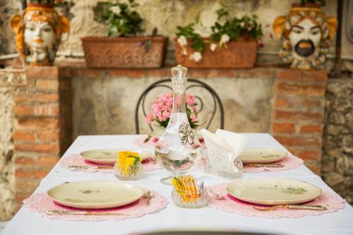 a table with plates and a vase on it at Villa Giannina B&B in Taormina