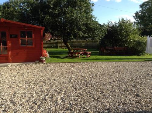 a red shed with a picnic table in the grass at B&B Dorwyn Manor in Avebury