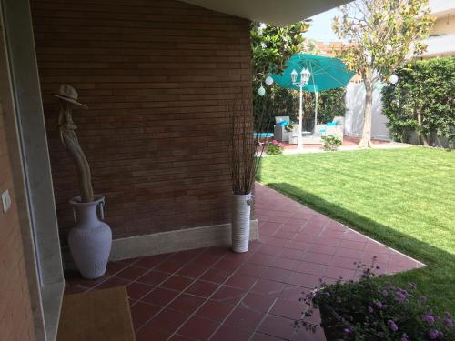 two vases sitting on a porch with an umbrella at Maison Tizi in Passoscuro