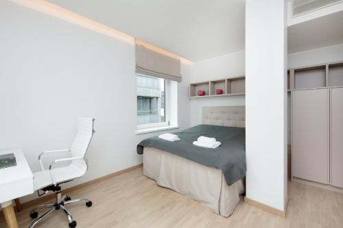 a bedroom with a bed and a desk and a chair at 8ERA Business Executive Rotermanni Apartments in Tallinn