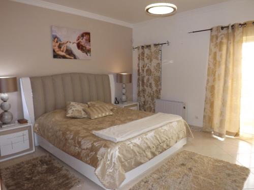 a bedroom with a large bed and a window at Villa Estrelamar in Boliqueime