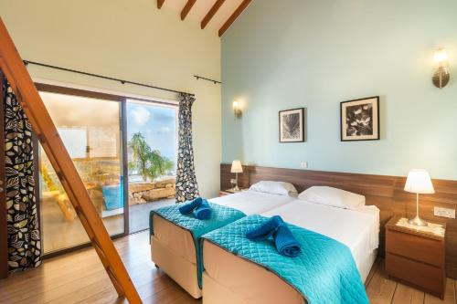 a bedroom with a bed and a large window at Oceania & Panorama Villas in Peyia