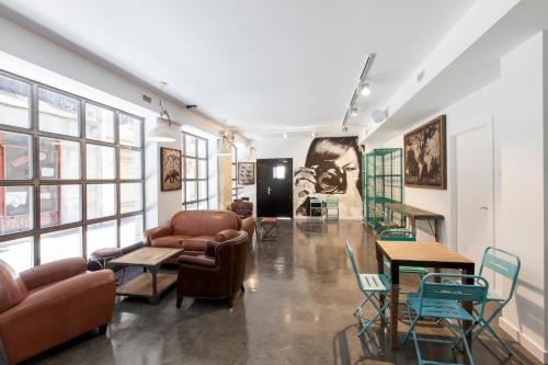 a room with couches chairs and tables and windows at Winederful Hostel & Café in Logroño