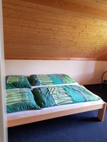 un letto in una stanza con soffitto in legno di Apartmany chaloupka a Tanvald