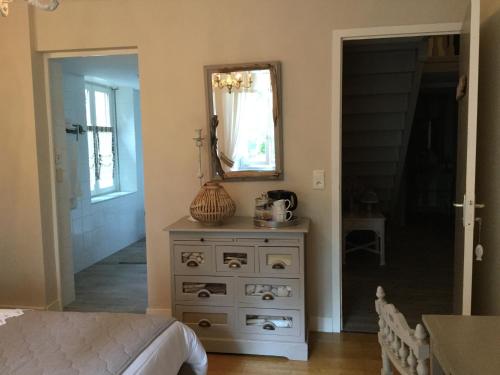 a bedroom with a dresser with a mirror on it at L'Orangerie de Camperos in Barsac