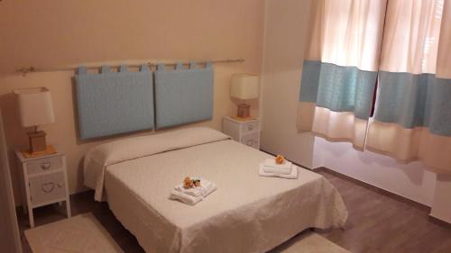 ポルト・トッレスにあるCamere Vacanze Acqua Chiaraの小さなベッドルーム1室(ベッド2台、タオル付)