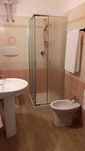 a bathroom with a shower and a toilet and a sink at Camere Vacanze Acqua Chiara in Porto Torres