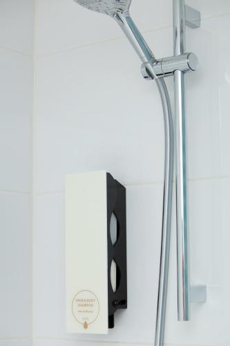 a shower head in a bathroom next to a speaker at 8ERA Business Executive Rotermanni Apartments in Tallinn
