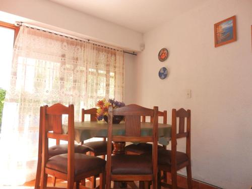 comedor con mesa, sillas y ventana a Complejo El Bosque en Villa Gesell