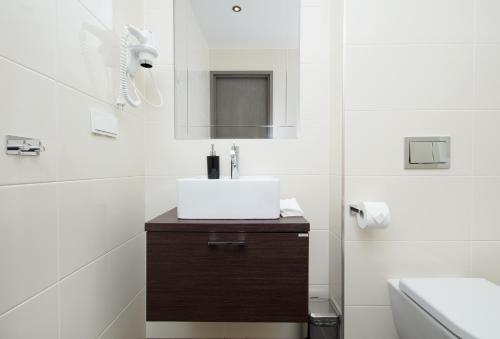 a white bathroom with a sink and a mirror at 8ERA Business Executive Rotermanni Apartments in Tallinn