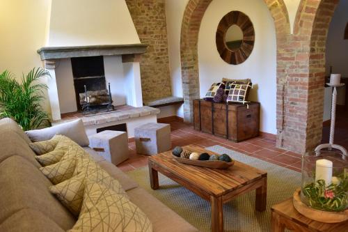 a living room with a couch and a fireplace at Villa San Michele in Barberino di Val dʼElsa