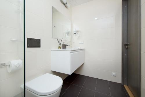 a white bathroom with a toilet and a sink at 8ERA Business Executive Rotermanni Apartments in Tallinn