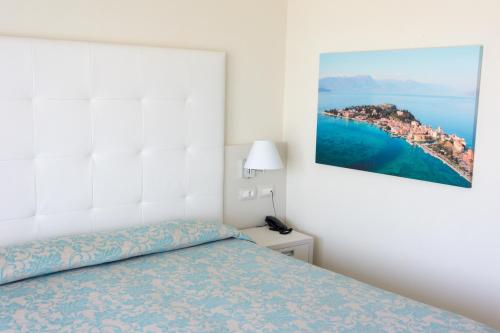 a bedroom with a bed and a painting on the wall at Hotel Holiday in Sirmione