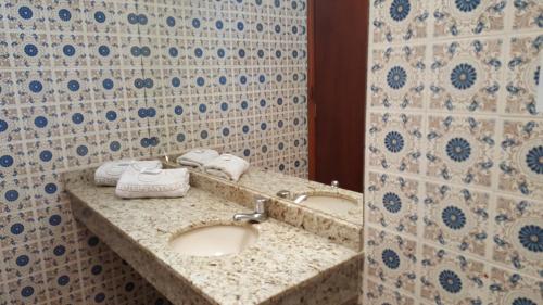 a bathroom with a sink and a mirror at Hotel Santa Rita Itu in Itu