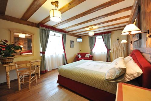 1 dormitorio con 1 cama, mesa y sillas en Affittacamere Le Relais De La Grandze en Doues