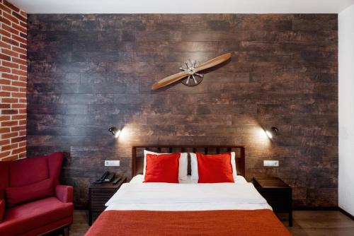 a bedroom with a bed with a ceiling fan and a red chair at LiKi LOFT HOTEL in Saint Petersburg